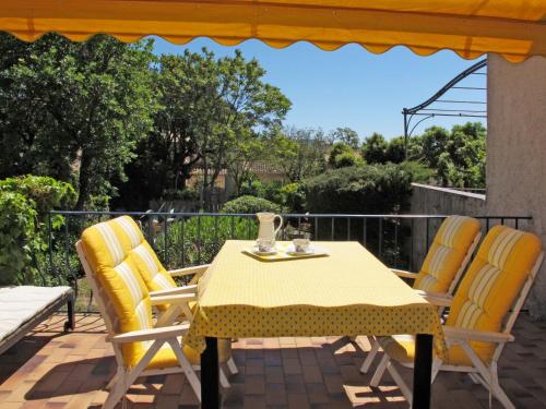 グリモーにあるHoliday Home La Maison bleue - GRI145 by Interhomeの黄色のテーブルと椅子が並ぶパティオ