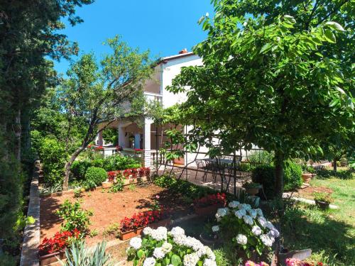 ein Garten vor einem Haus mit Blumen in der Unterkunft Apartment Mila-2 by Interhome in Jadranovo