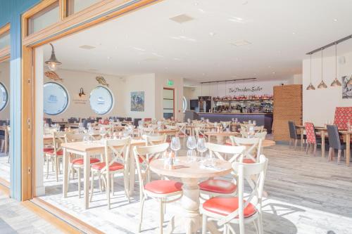 un ristorante con tavoli bianchi e sedie rosse di The Ship Inn a Musselburgh