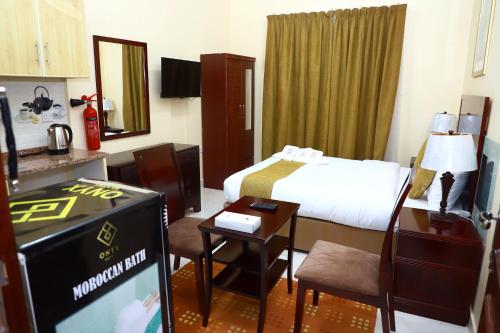 Habitación de hotel con cama y TV en Onyx Hotel Apartments - MAHA HOSPITALITY GROUP en Ajman 