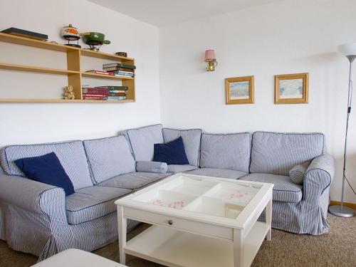 a living room with a blue couch and a coffee table at Apartment Arzinol 402 by Interhome in Les Collons