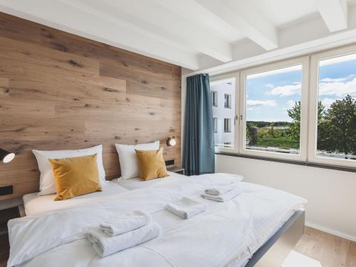 een slaapkamer met 2 bedden en een groot raam bij Apartment Mariandl am Meer-5 by Interhome in Staphel