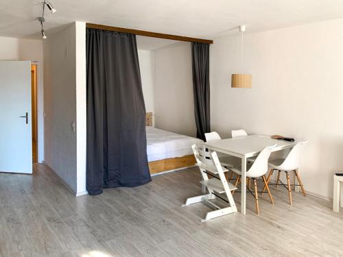 una camera con letto, tavolo e sedie di Apartment Parkareal - Utoring-21 by Interhome a Bolgen