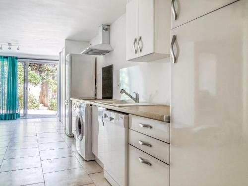 a white kitchen with a sink and a dishwasher at Apartment Les Chevrefeuilles by Interhome in La Valette-du-Var