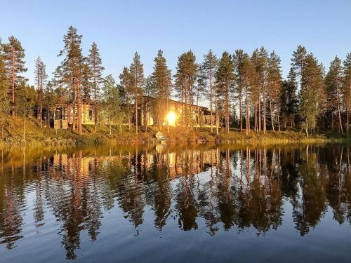 a house on the shore of a lake at night at Holiday Home Jussis chalet b by Interhome in Kuusamo