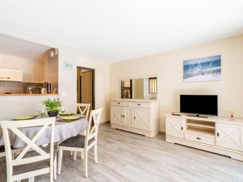 un salon avec une table à manger et une télévision dans l'établissement Apartment La Miougrano-2 by Interhome, à Fréjus