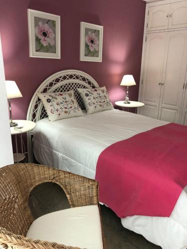 1 dormitorio con 1 cama blanca y paredes rosas en Ático Los Rombos, en Puerto Naos