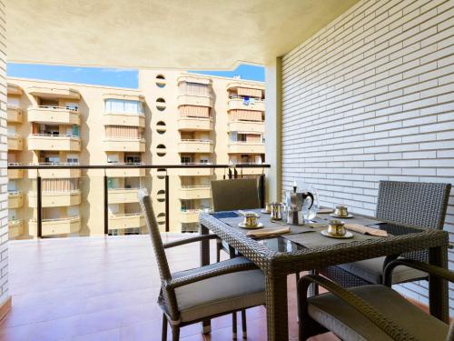 a dining table and chairs on a balcony with a building at Apartment Vila de Oropesa X by Interhome in Oropesa del Mar