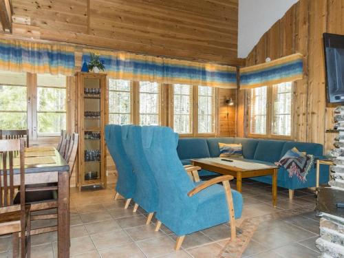 a living room with a blue couch and a table at Holiday Home Lauri 4 iso by Interhome in Sirkka
