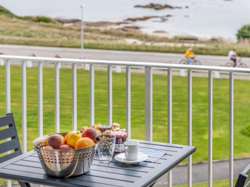 a bowl of fruit sitting on a table on a balcony at Apartment Les Trois Iles-9 by Interhome in Quiberon