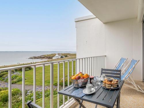 un tavolo su un balcone con un cesto di frutta di Apartment Les Trois Iles-9 by Interhome a Quiberon