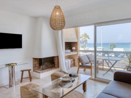 d'un salon avec une cheminée et une vue sur l'océan. dans l'établissement Apartment La Rose des Sables by Interhome, à Saint-Cyr-sur-Mer