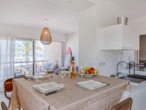 une cuisine et une salle à manger avec une table et des verres à vin dans l'établissement Apartment La Rose des Sables by Interhome, à Saint-Cyr-sur-Mer