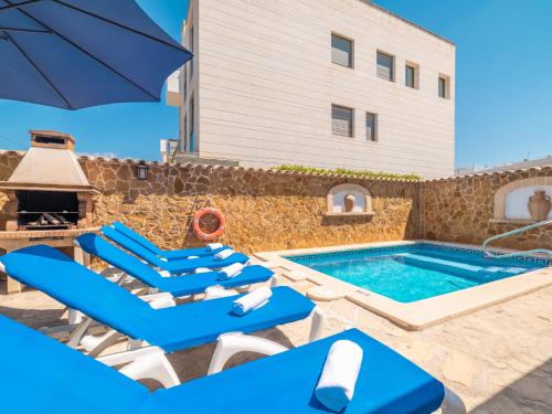 a swimming pool with lounge chairs and an umbrella at Holiday Home Pintor Beach House by Interhome in Port de Pollensa