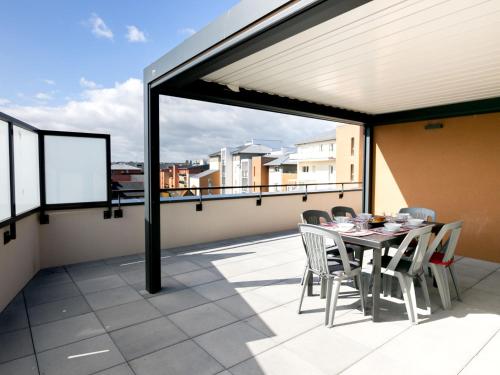 een patio met een tafel en stoelen op een balkon bij Apartment Résidence de l'Hermine by Interhome in Saint-Malo