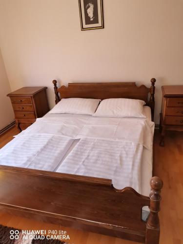 1 dormitorio con cama de madera con sábanas blancas en Apartmens Kenedy lux en Kiseljak