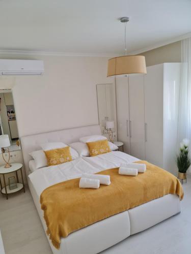 - une chambre blanche avec un grand lit et 2 oreillers dans l'établissement Kolibri Apartman, à Szeged