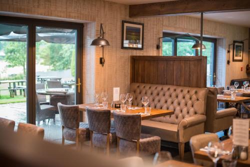 a restaurant with tables and chairs and a couch at Forest in Burnley