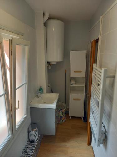 a small bathroom with a sink and a refrigerator at DIEPPE au coeur du cville-Calme avec balcon in Dieppe