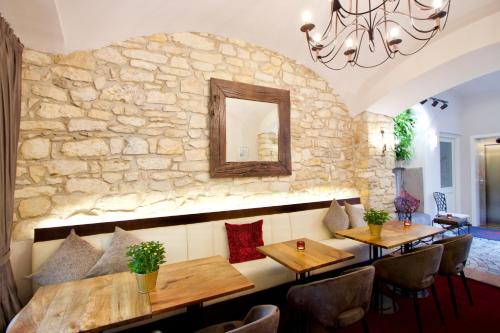 a restaurant with wooden tables and a stone wall at Hotel Residence Agnes in Prague