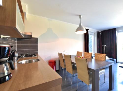 a kitchen and dining room with a wooden table and chairs at Resort De Vlasschure in Wissenkerke