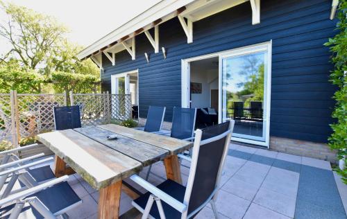 a wooden table and chairs on a patio at Resort De Vlasschure in Wissenkerke