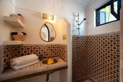 ein Bad mit einem Waschbecken und einem Spiegel in der Unterkunft Riad Miloud en exclusivité 10 P au cœur de la Médina in Marrakesch