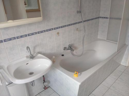 Gästewohnung SEETOR في Lenzen: حمام مع حوض وحوض استحمام مع حوض