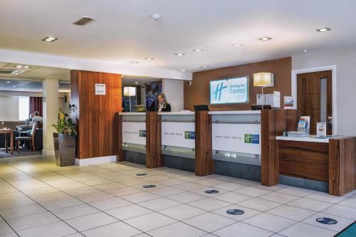 Eine Frau, die an einer Kasse in einer Lobby steht. in der Unterkunft Holiday Inn Express Leeds-East, an IHG Hotel in Leeds