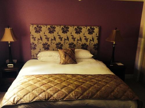 a cat laying on a bed in a bedroom at Mansion House Hotel in Elgin