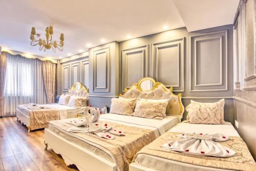 a hotel room with two beds and a chandelier at Sirkeci Ersu Hotel & SPA in Istanbul
