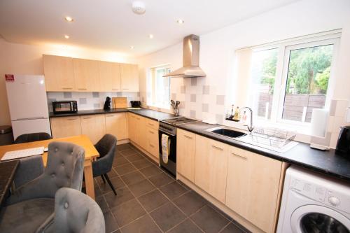 a kitchen with a table and chairs and a counter top at Ideal Lodgings in Bury - Redvales in Bury