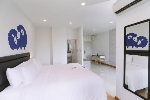 a bedroom with a large white bed with blue signs on the wall at Kokotel Bangkok Sukhumvit 50 in Bangkok