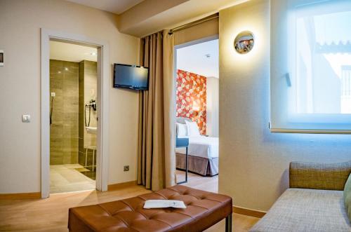 マドリードにあるホテル メニナス ブティック オペラのリビングルーム(ソファ付)、ベッドルーム1室が備わります。