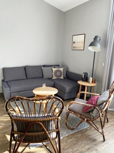 a living room with a couch and chairs and a table at Les Chambres de l'Imprimerie in Beaune