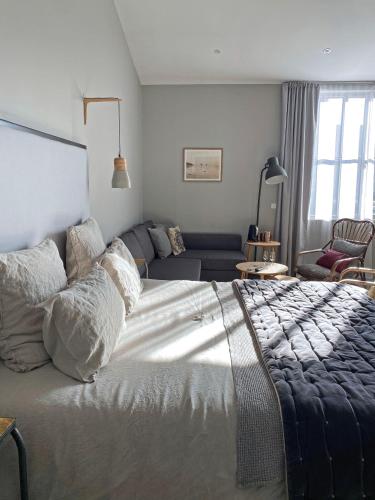 a bedroom with a large bed and a couch at Les Chambres de l'Imprimerie in Beaune