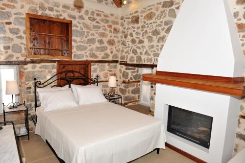 a bedroom with a bed and a fireplace at Guesthouse Alexandra in Hydra