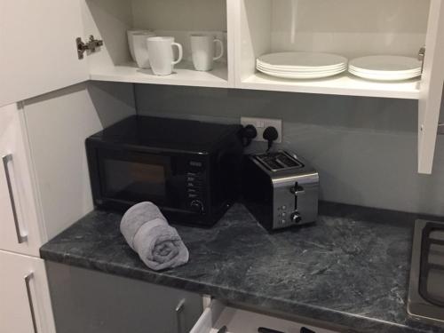 a kitchen counter with a microwave and a toaster oven at Showcase Apartments - Kimberley House in Leicester