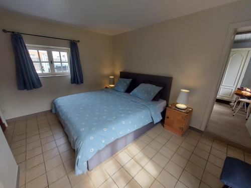 a bedroom with a blue bed with blue pillows at Au Chant des Oiseaux in Tournai