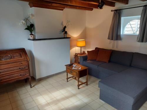 uma sala de estar com um sofá e uma mesa em Au Chant des Oiseaux em Tournai