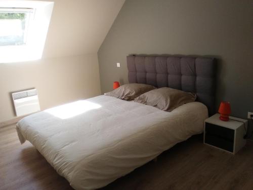 Schlafzimmer mit einem großen weißen Bett und einem Fenster in der Unterkunft Villa Fétuque Crin d'Ours à Merlimont in Merlimont