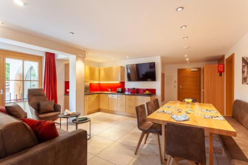 a living room with a table and a kitchen at Apart-Hotel Alpinsonnenresidenz in Fiss