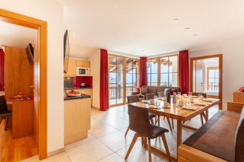 cocina y sala de estar con mesa de comedor en Apart-Hotel Alpinsonnenresidenz, en Fiss