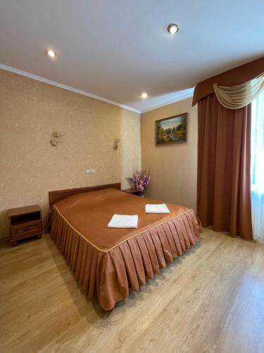 a bedroom with a bed with two towels on it at Gusarskiy Hotel and Apartment in Kyiv