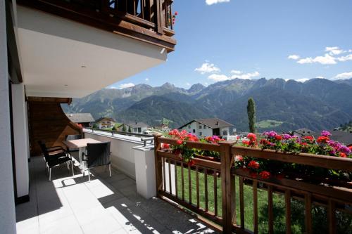 a balcony with flowers and a view of mountains at Apart-Hotel Alpinsonnenresidenz in Fiss