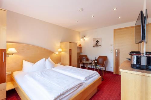 a hotel room with a large bed and a kitchen at Apart-Hotel Alpinsonnenresidenz in Fiss