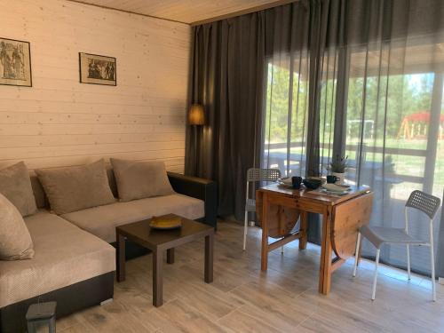 - un salon avec un canapé et une table dans l'établissement Natura Domki Anastazewo, à Anastazewo