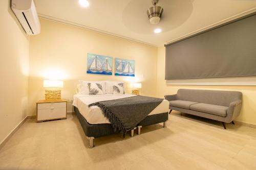 1 dormitorio con cama, sofá y pizarra en Casa Bahía Apartamento en Cartagena de Indias