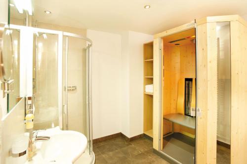 a bathroom with a shower and a sink at Apart-Hotel Alpinsonnenresidenz in Fiss