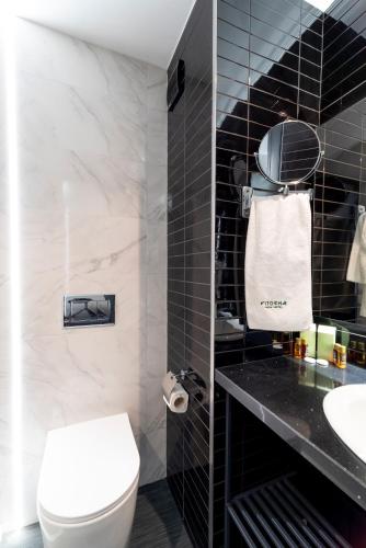 a bathroom with a white toilet and a sink at Vitosha Park Hotel - Free Indoor Pool & Parking in Sofia